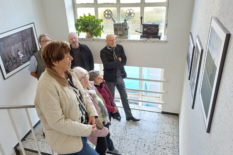 Eine Gruppe von Besuchern betrachten Porträts