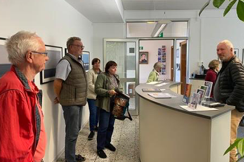 Eine Gruppe von Menschen erhält eine Einführung in eine Fotoausstellung